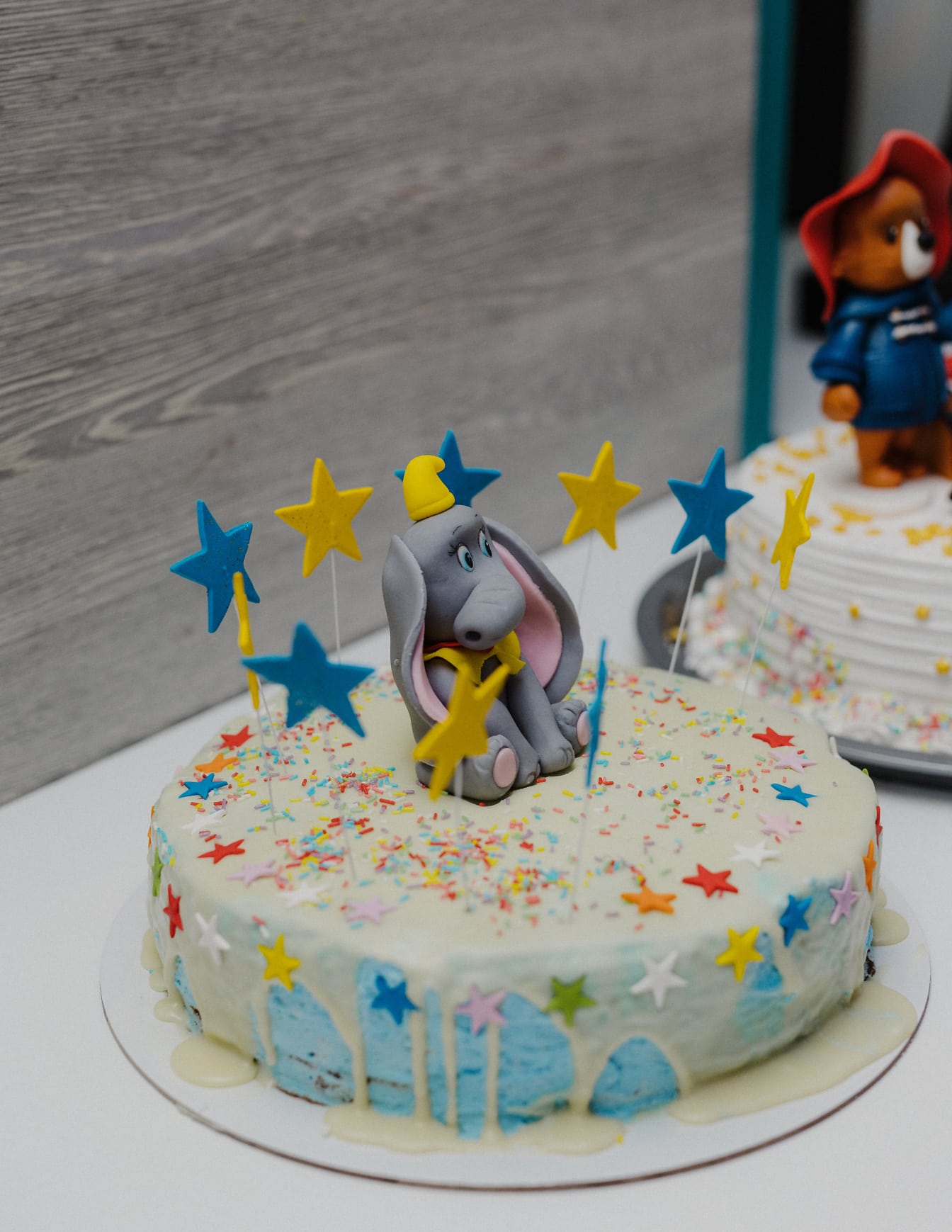 코끼리 장식과 파란색과 노란색 별이 있는 생일 케이크