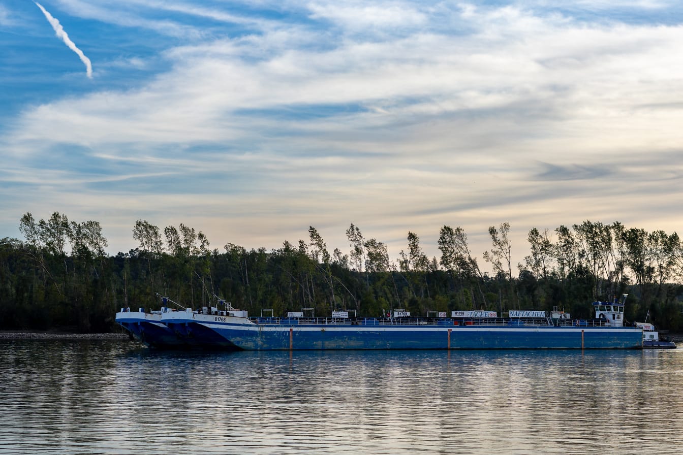 Tàu chở hàng sà lan màu xanh đậm trên sông Danube