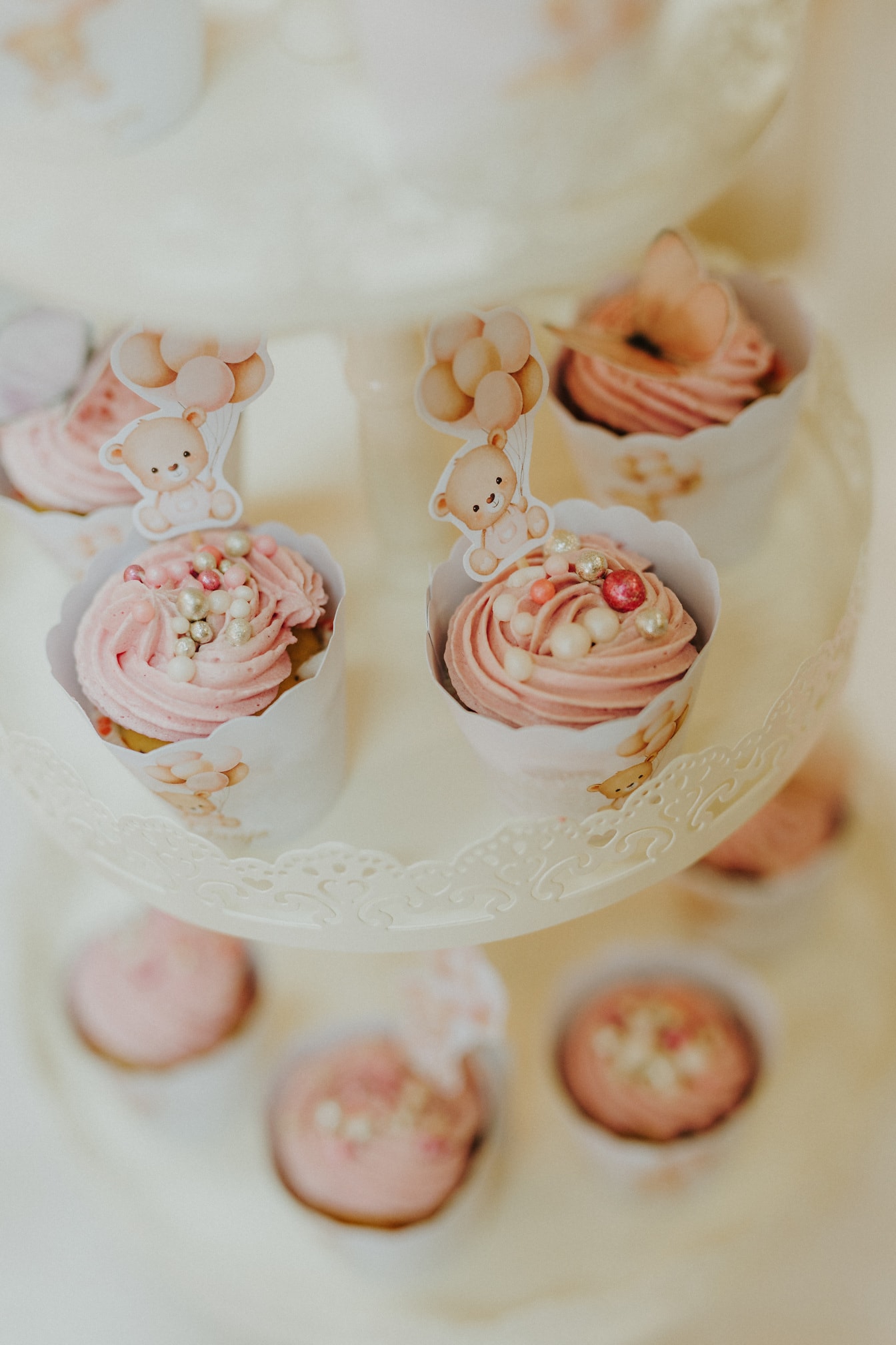 Creamy pinkish cupcakes with perl and teddy bear decoration