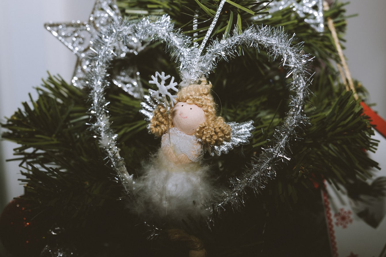 Patung malaikat dalam ornamen dekoratif hati untuk pohon Natal