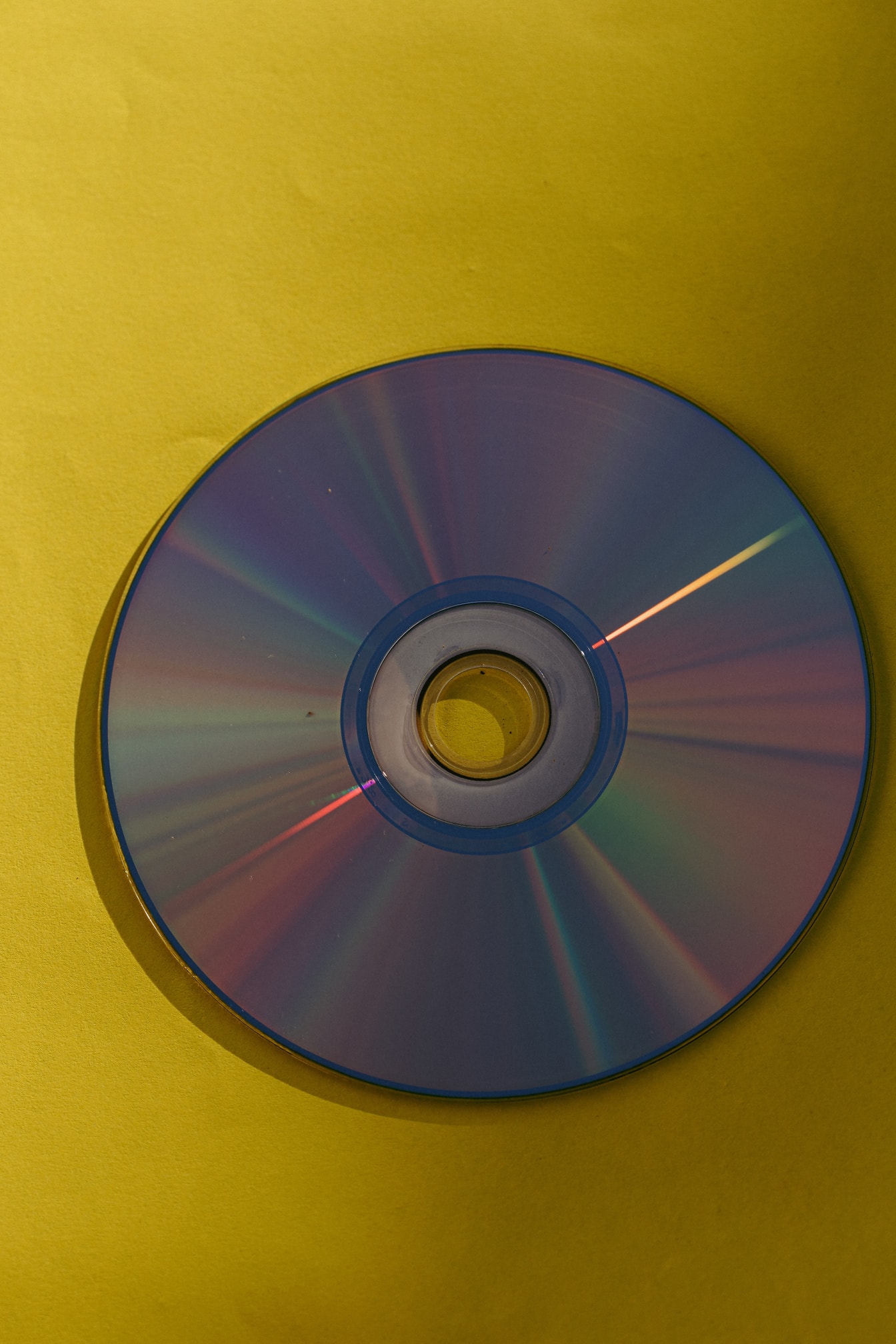 Back-up dvd-schijf met glanzende reflectie op geel papier