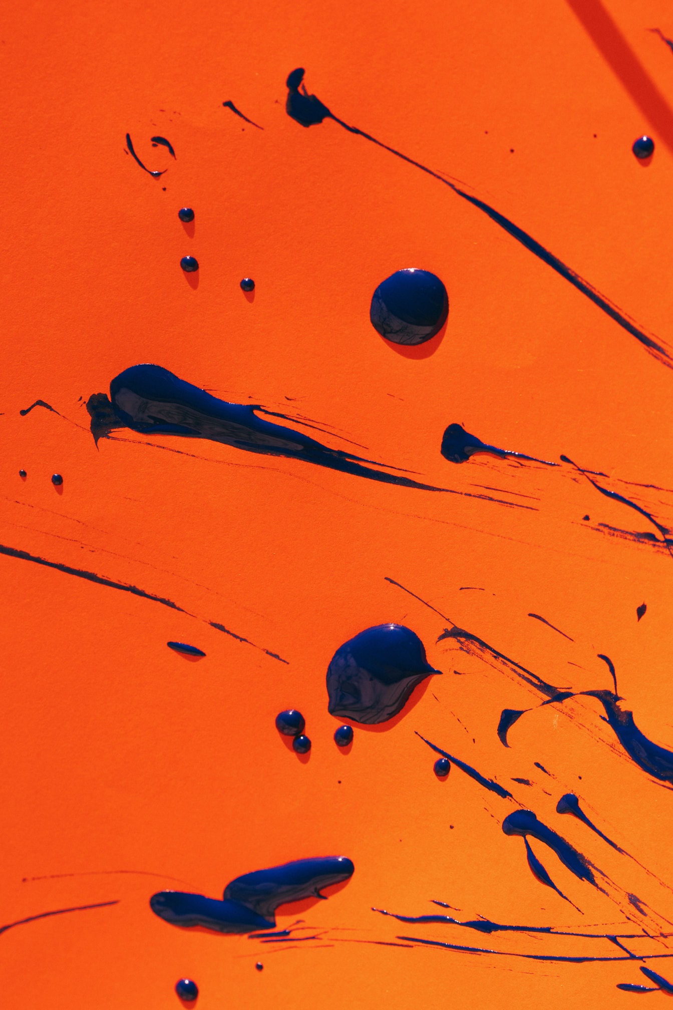 Kék akvarell festék fröccsenése narancssárga háttér előtt