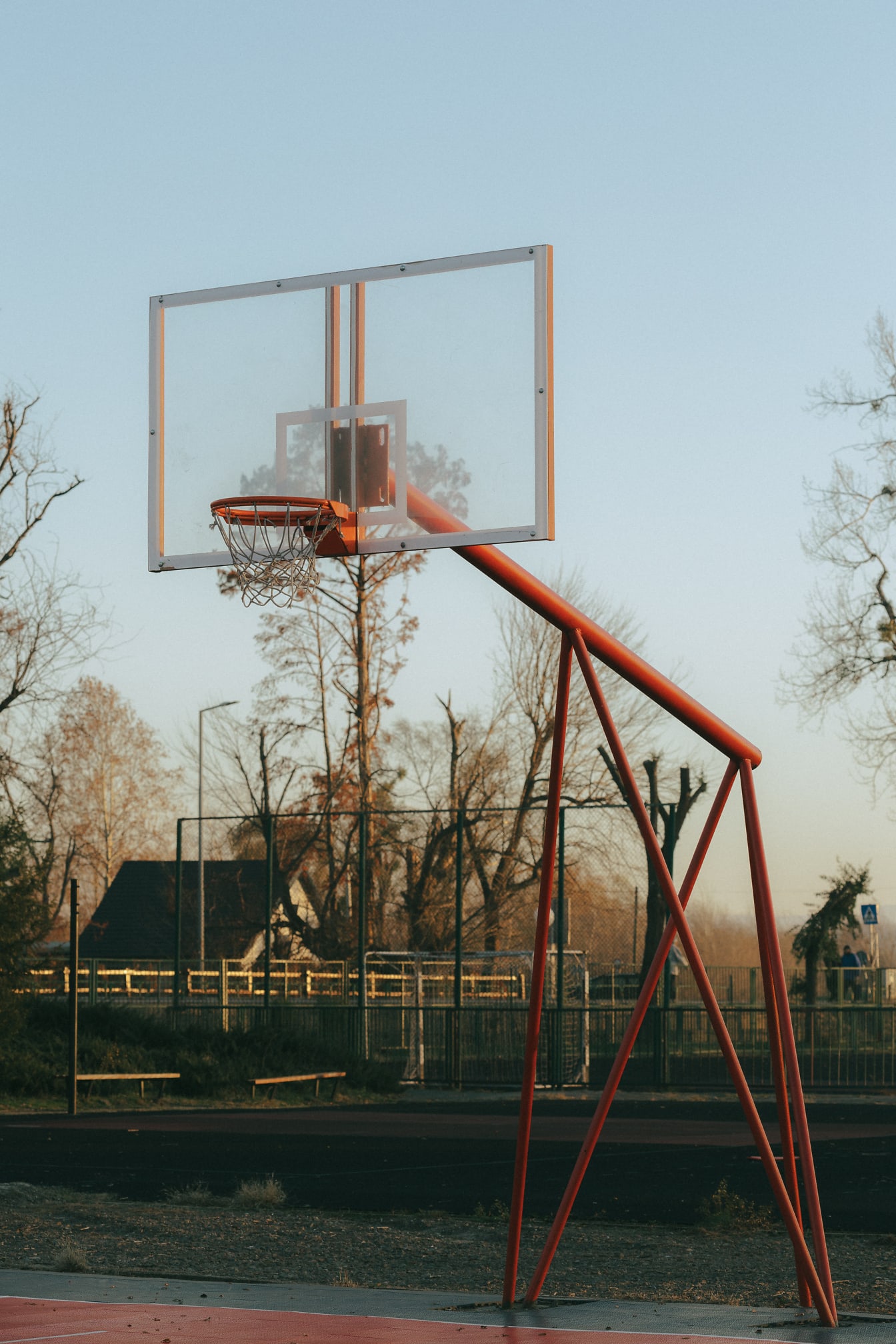 Άδειο γήπεδο μπάσκετ με καλάθι με κοκκινωπή μεταλλική κατασκευή