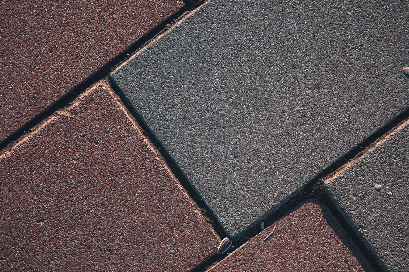 Textura chodníku s načervenalými a šedými bloky zblízka