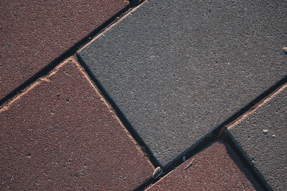 Pavement texture with reddish and grey blocks close-up photo