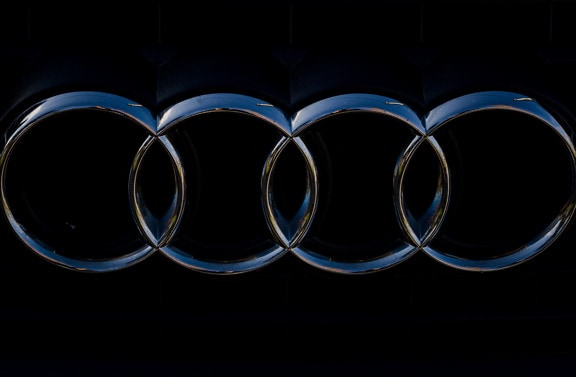 Skinnende metallisk Audi kromskilt på mørk baggrund