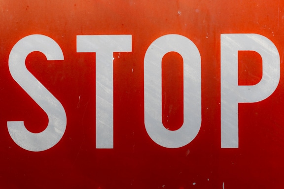 Word stop on red traffic sign close-up