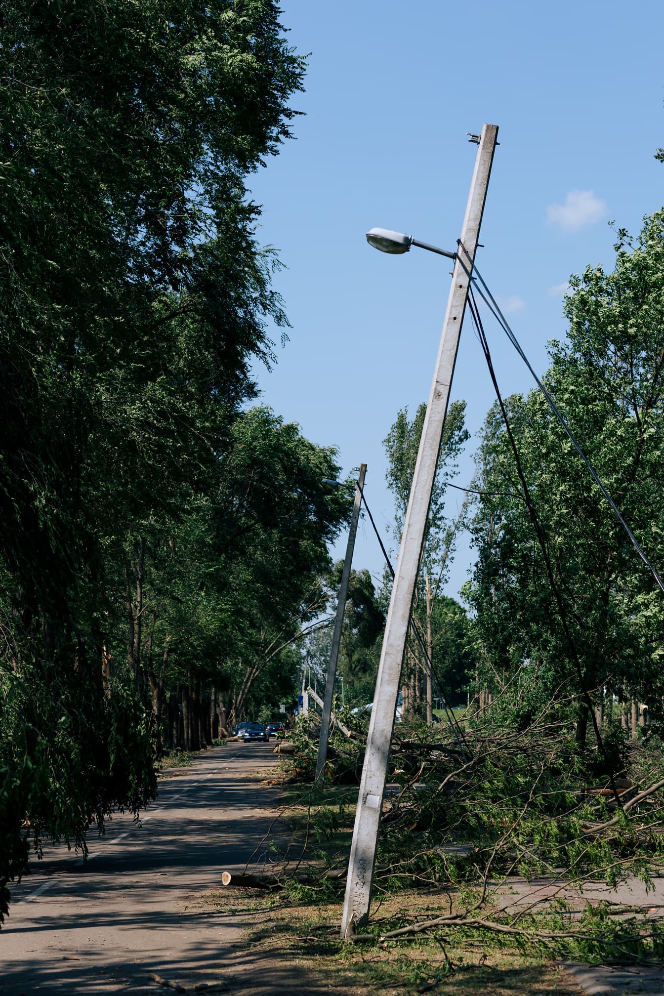 Λυγισμένοι τσιμεντένιοι τηλεφωνικοί στύλοι στο δρόμο μετά από ισχυρό άνεμο