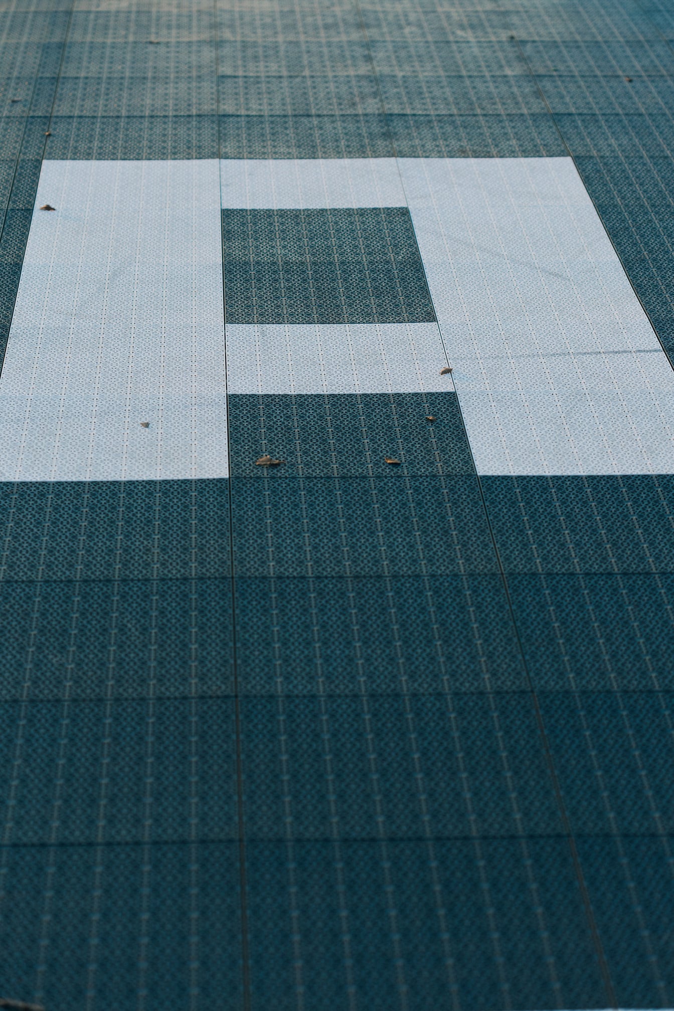 Nærbillede af et bogstav (A) på gulvet med geometrisk plastmønster