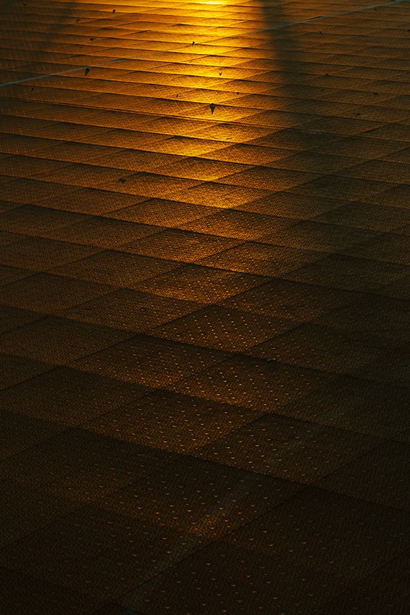 Orange gul solljusreflektion på marken med plastytan i skymningen