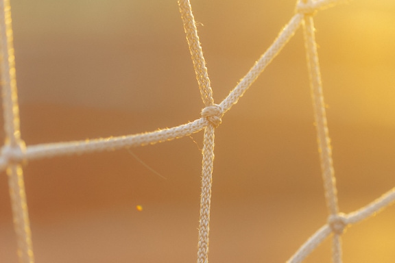 White nylon net fiber with yellowish sunlight as background close up photo