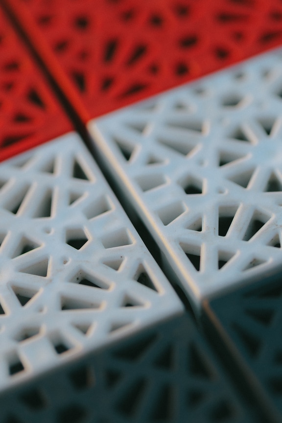 Nærbilde av en rød og hvit plasttekstur med geometrisk form