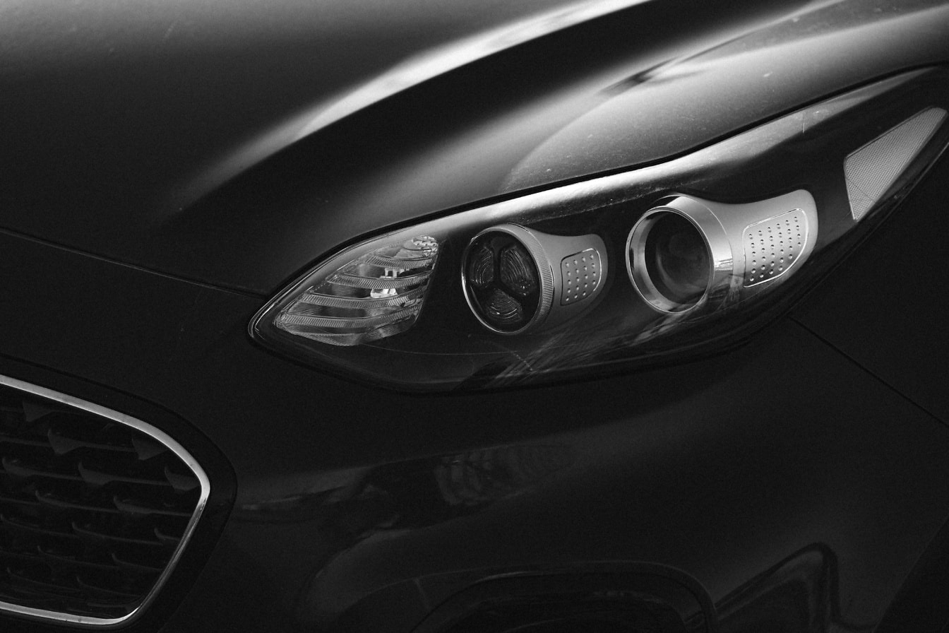 Headlight of a modern sedan car monochrome photograph