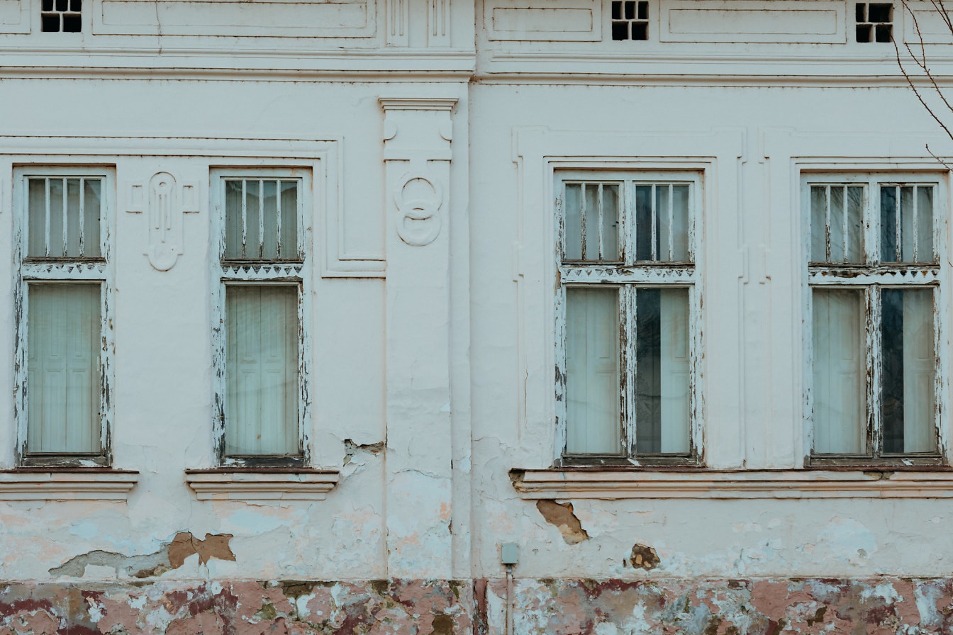 บ้านที่อยู่อาศัยเก่าที่มีหน้าต่างผุพังและซุ้ม