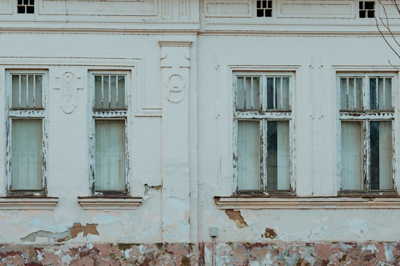 朽ち果てた窓とファサードのある古い住宅