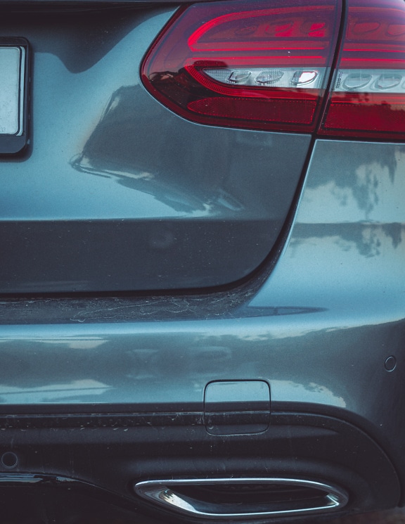 Das Heck eines metallic-grauen Autos mit scharfem Rücklicht im Fokus