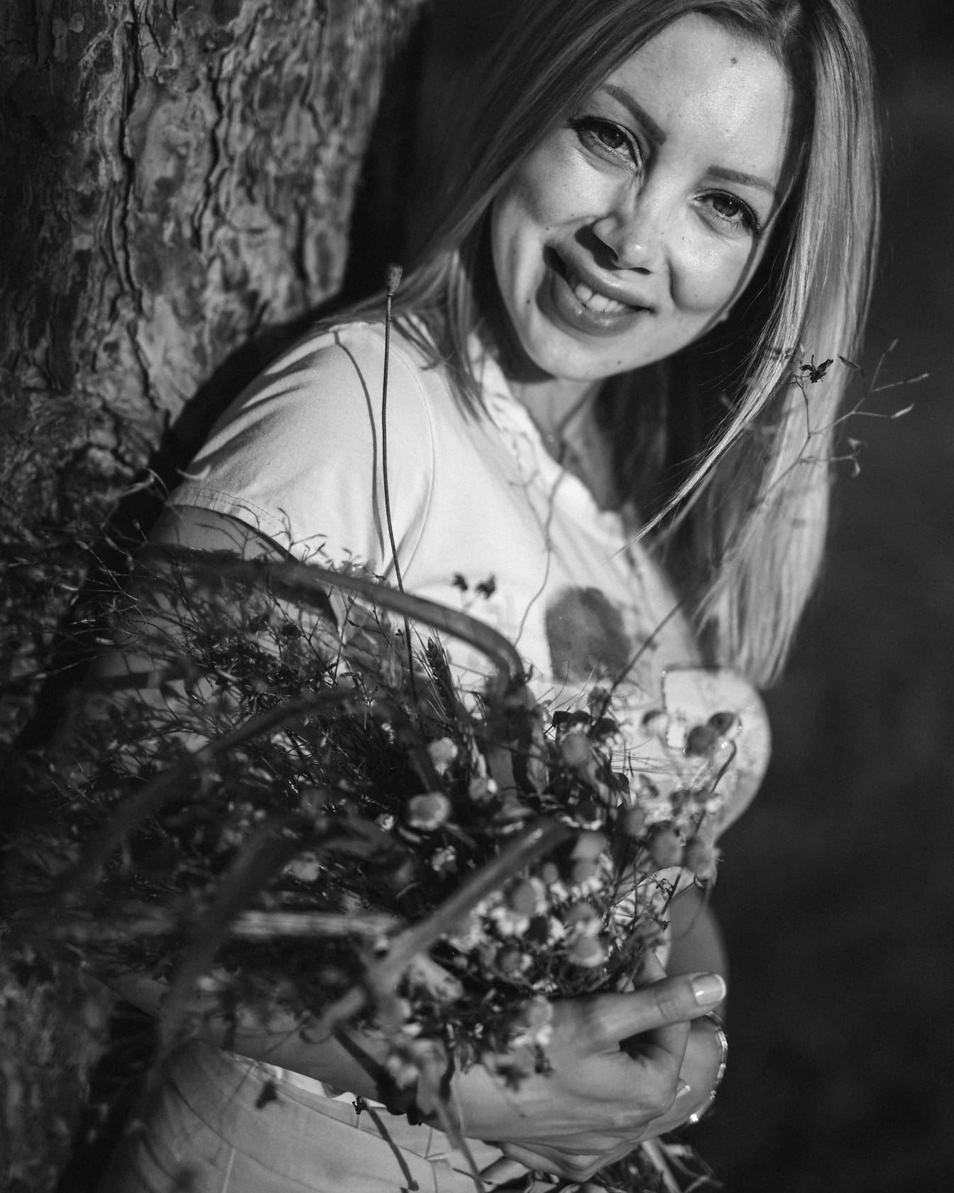 Vrouw die een boeket van bloemen zwart-witte foto houdt
