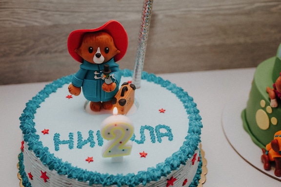 Birthday cake with a toy bear decoration on top