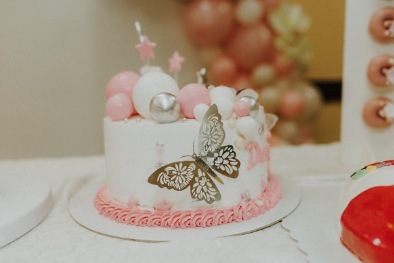 Cake with pink frosting and shining butterfly decoration