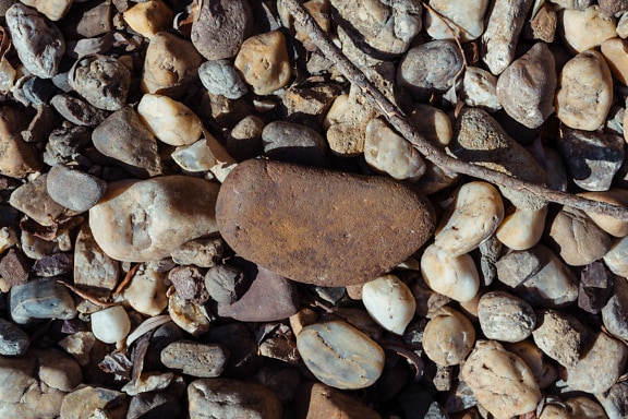 Grande rocha de granito no chão com seixos