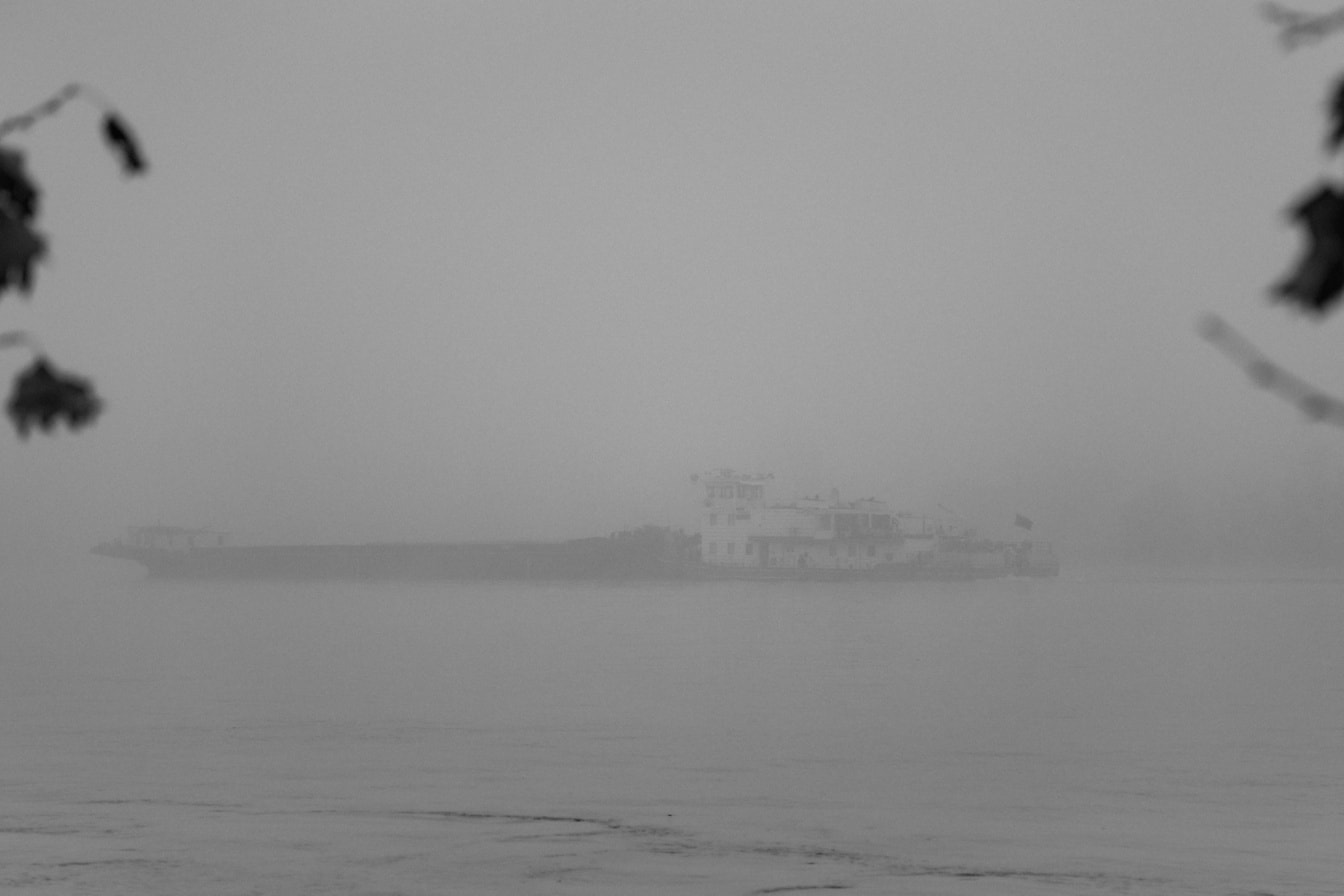 Ship in the dense fog on Danube river black and white photograph