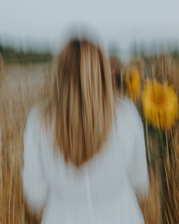 Intentionally blurry photo of woman in a field of wheat