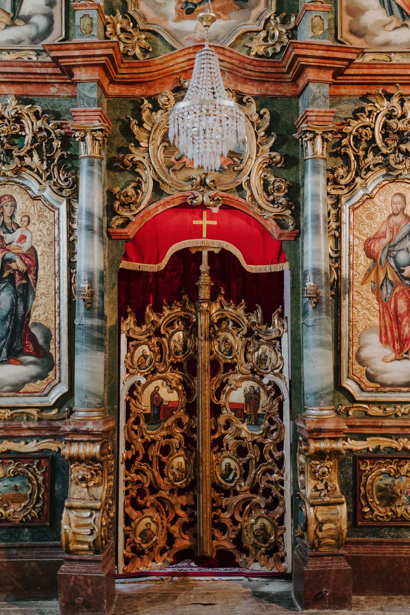 Vstupní dveře na oltář v ruském pravoslavném kostele s křišťálovým lustrem nahoře