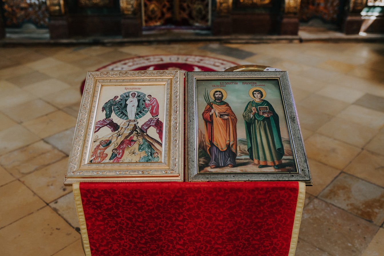 Dwa oprawione obrazy prawosławnych świętych na stole w klasztorze