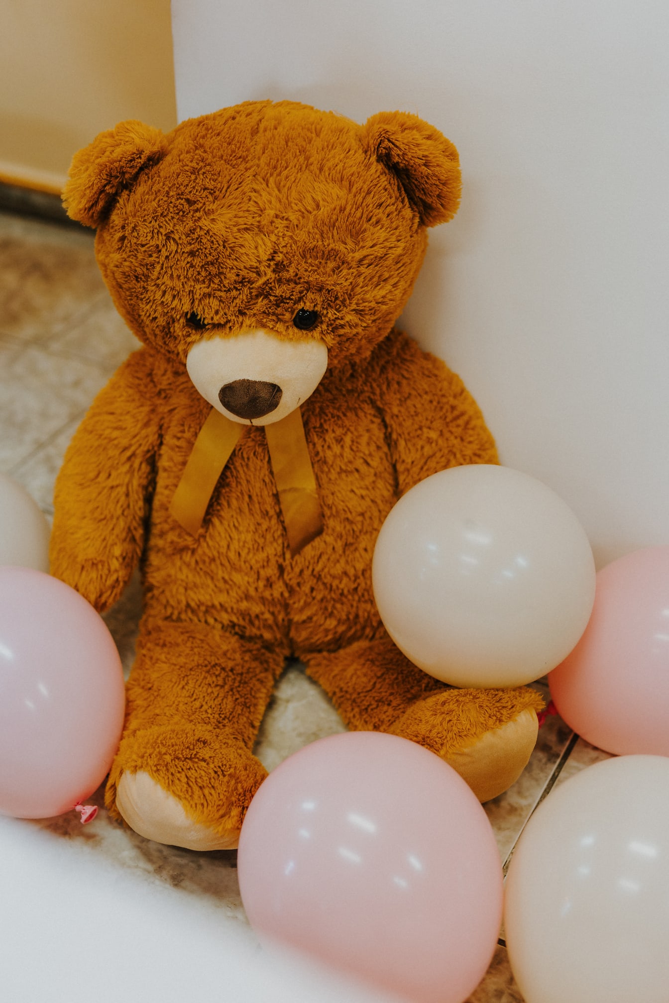 Boneka beruang coklat besar dengan balon