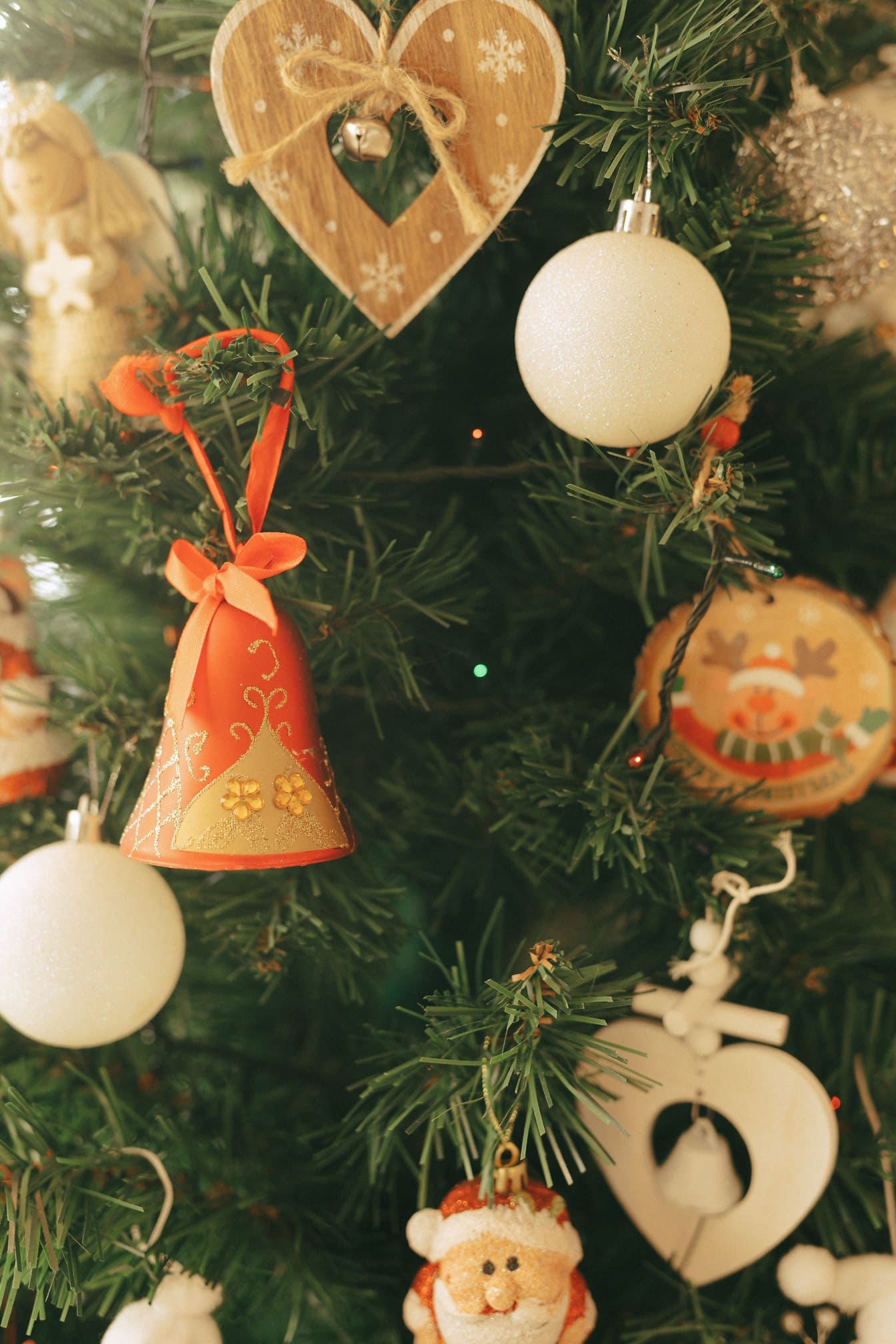 하트와 종과 산타 클로스 모양의 구식 장식품이있는 크리스마스 트리
