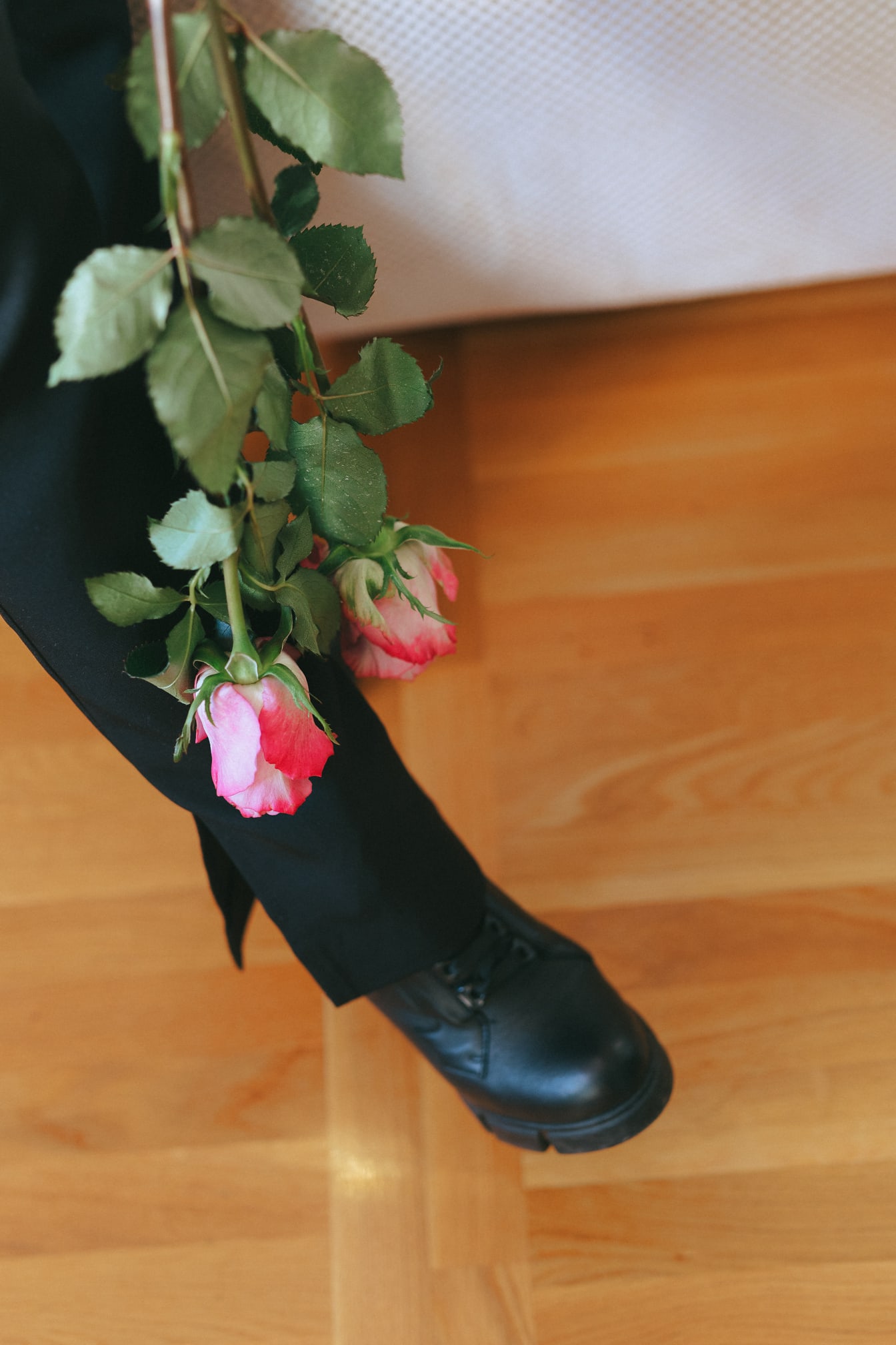 Chân của người với một bó hoa hồng hồng