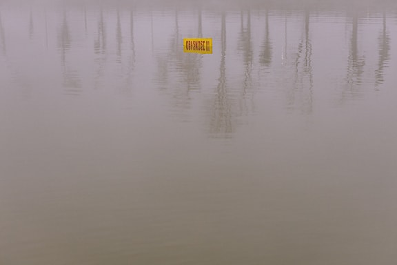 Warnschild gelbes Schild halb im Wasser untertauchen
