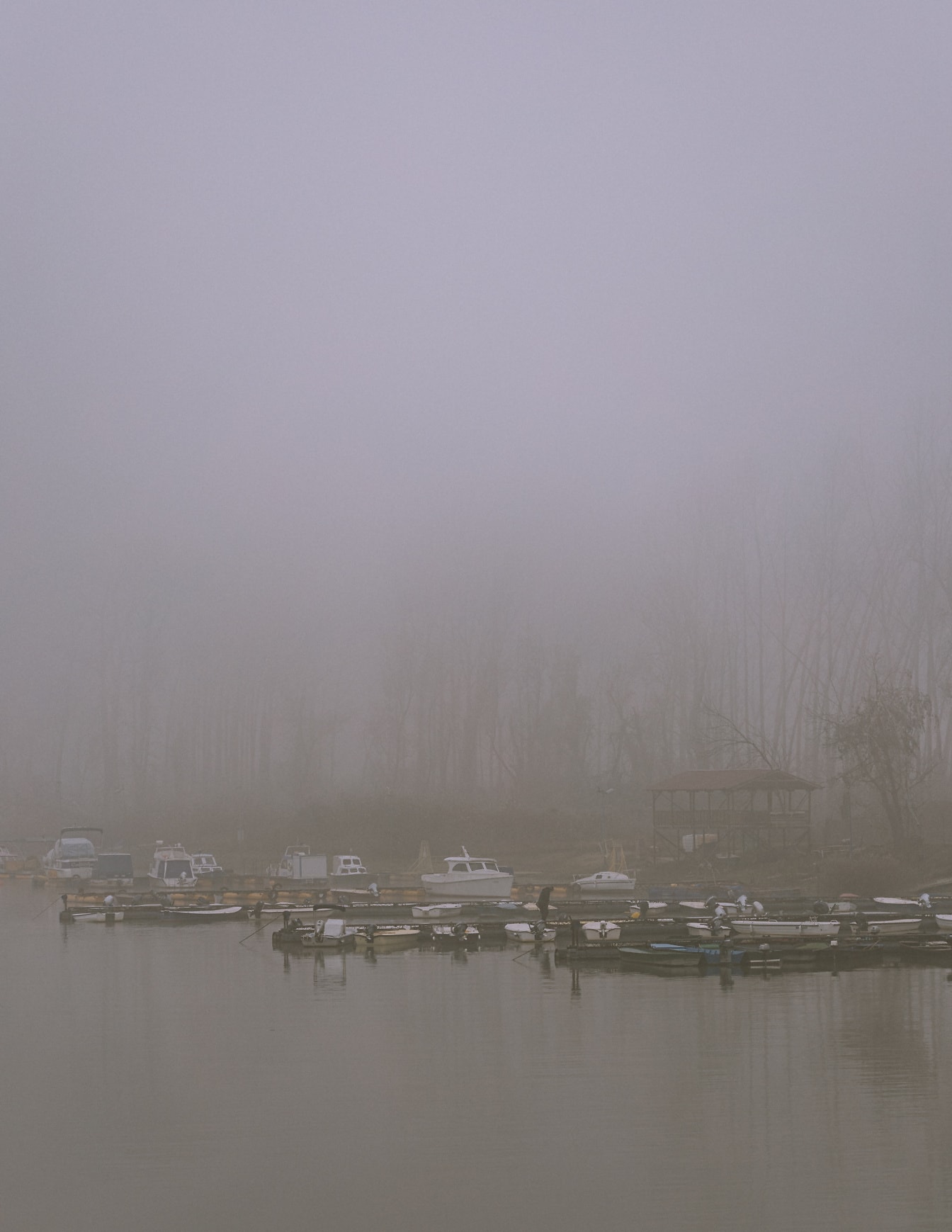 Kleine Fischerboote auf dem Wasser bei dichtem Nebel