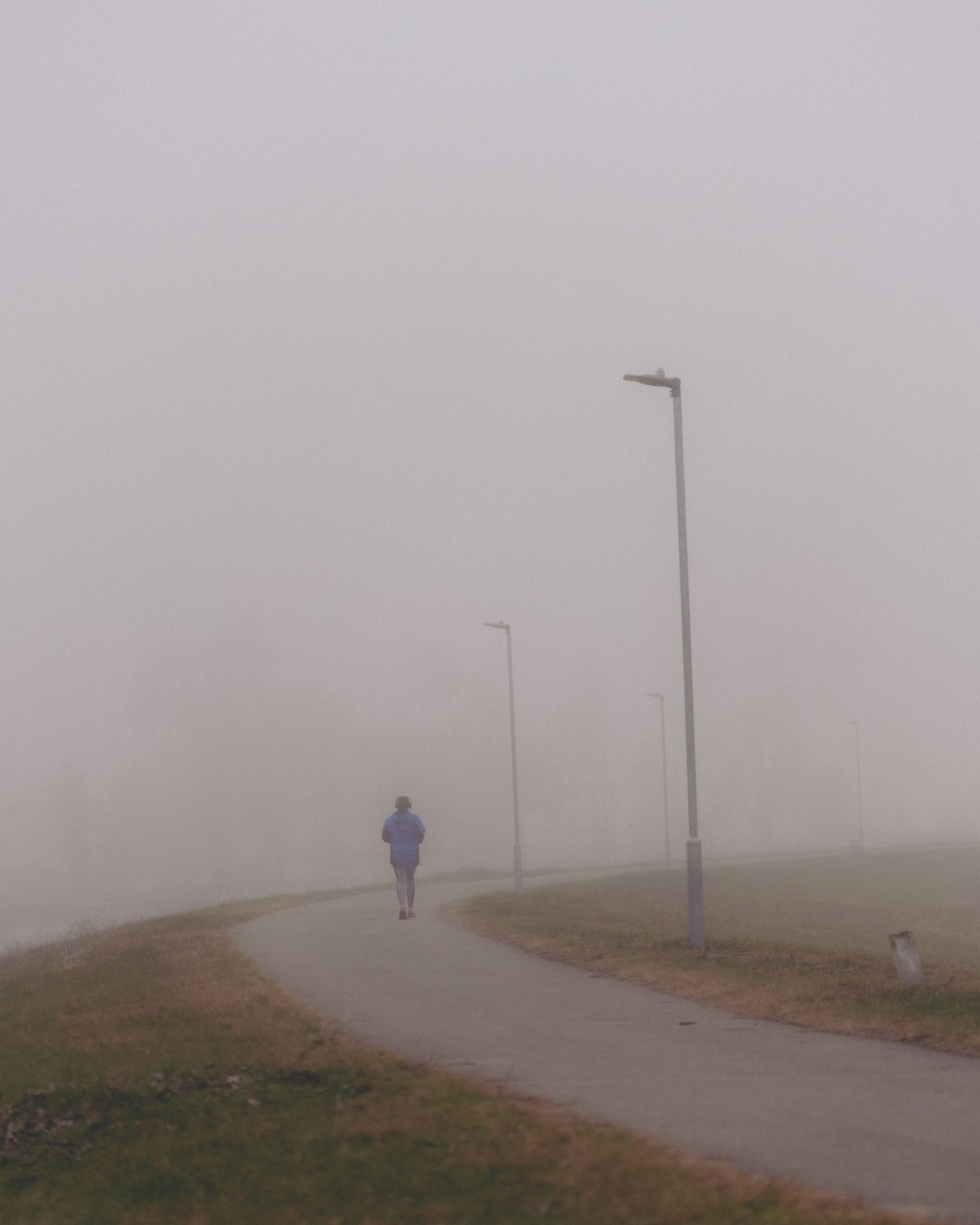 Persona que camina sola en un día de niebla