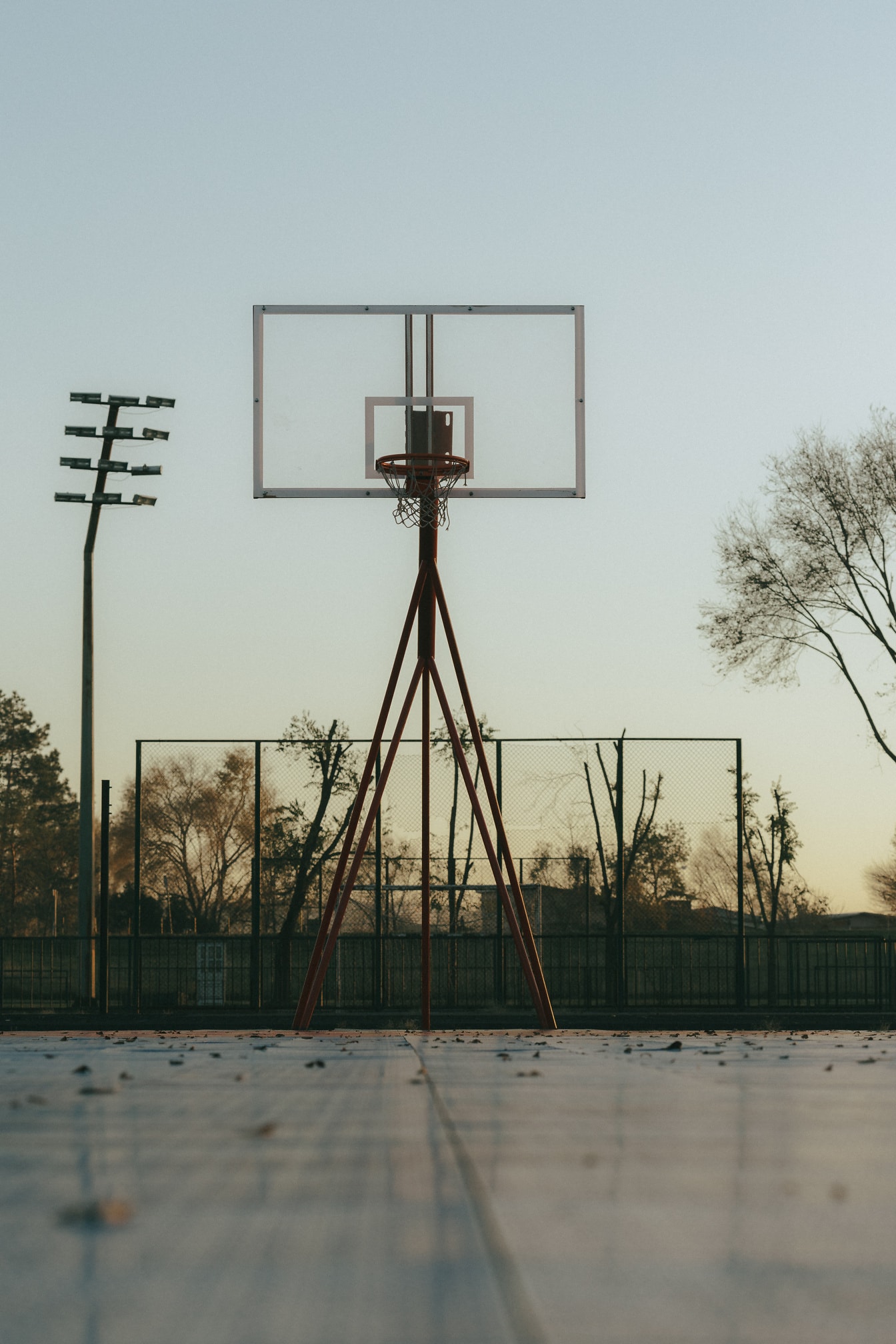 Aro de basquete com backboard transparente na quadra de basquete vazia