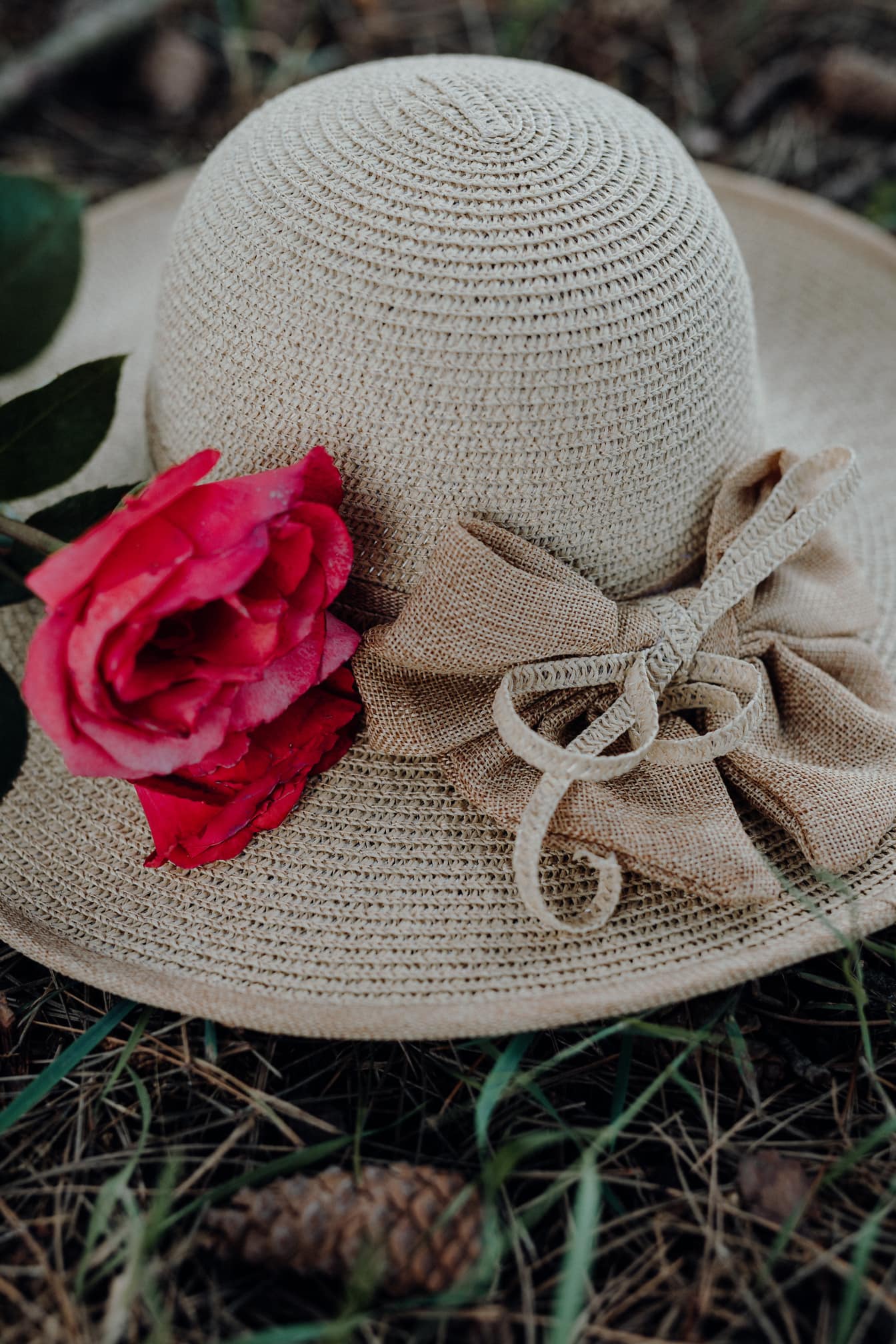 Modieuze handgemaakte hoed met een roodachtige roos erop