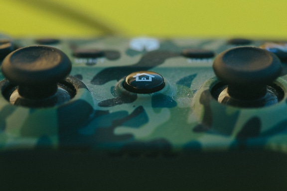 Joystick with round button of a video game controller in focus