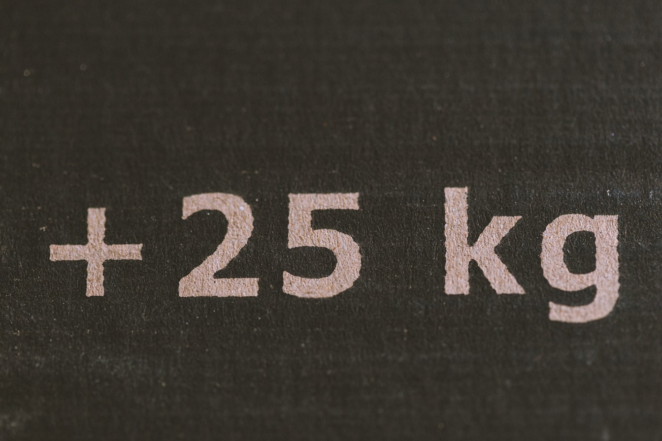 인쇄된 흰색 정보 (25 kg) 있는 검은색 용지 표면