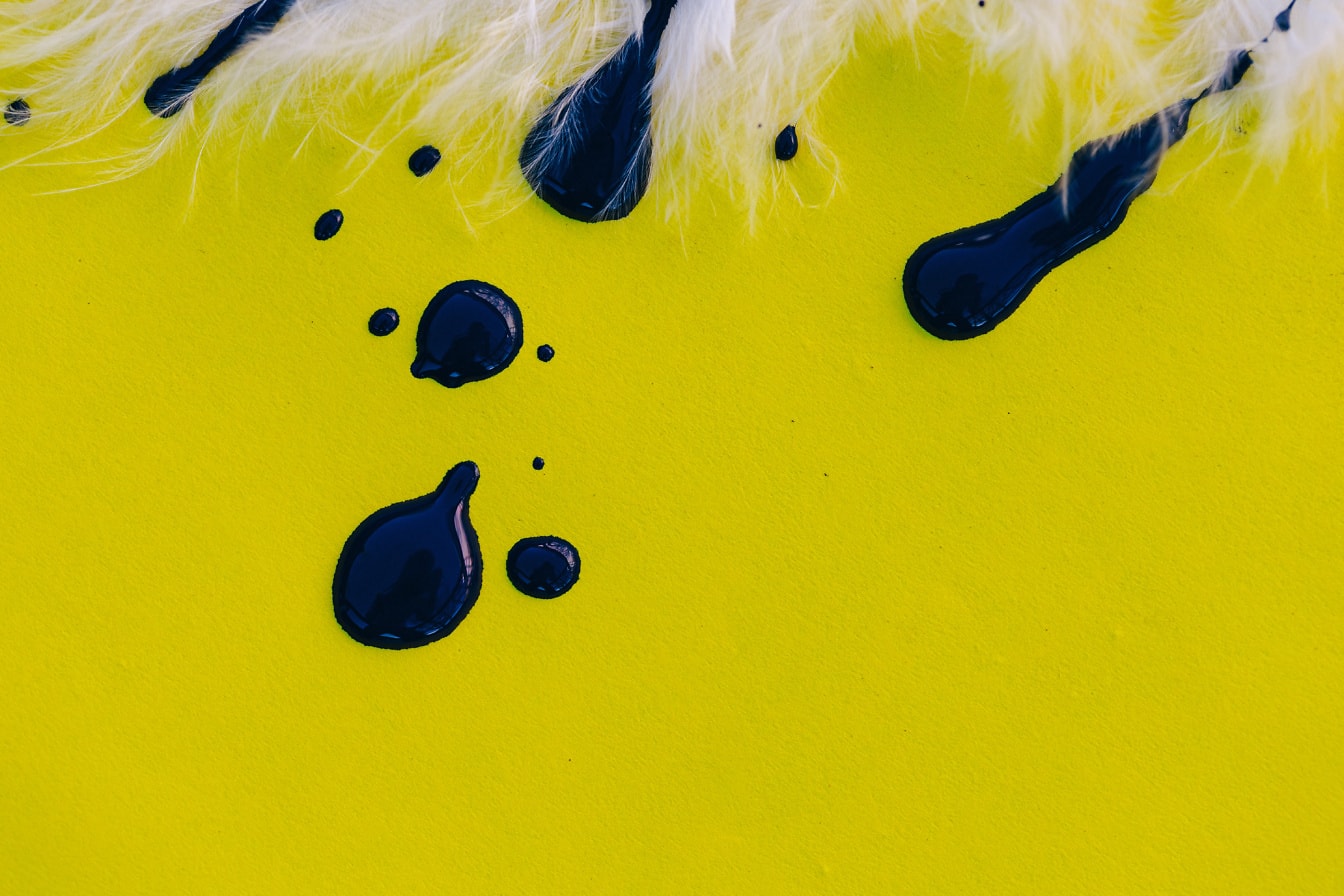 Svart akrylfärg på en gul yta närbild