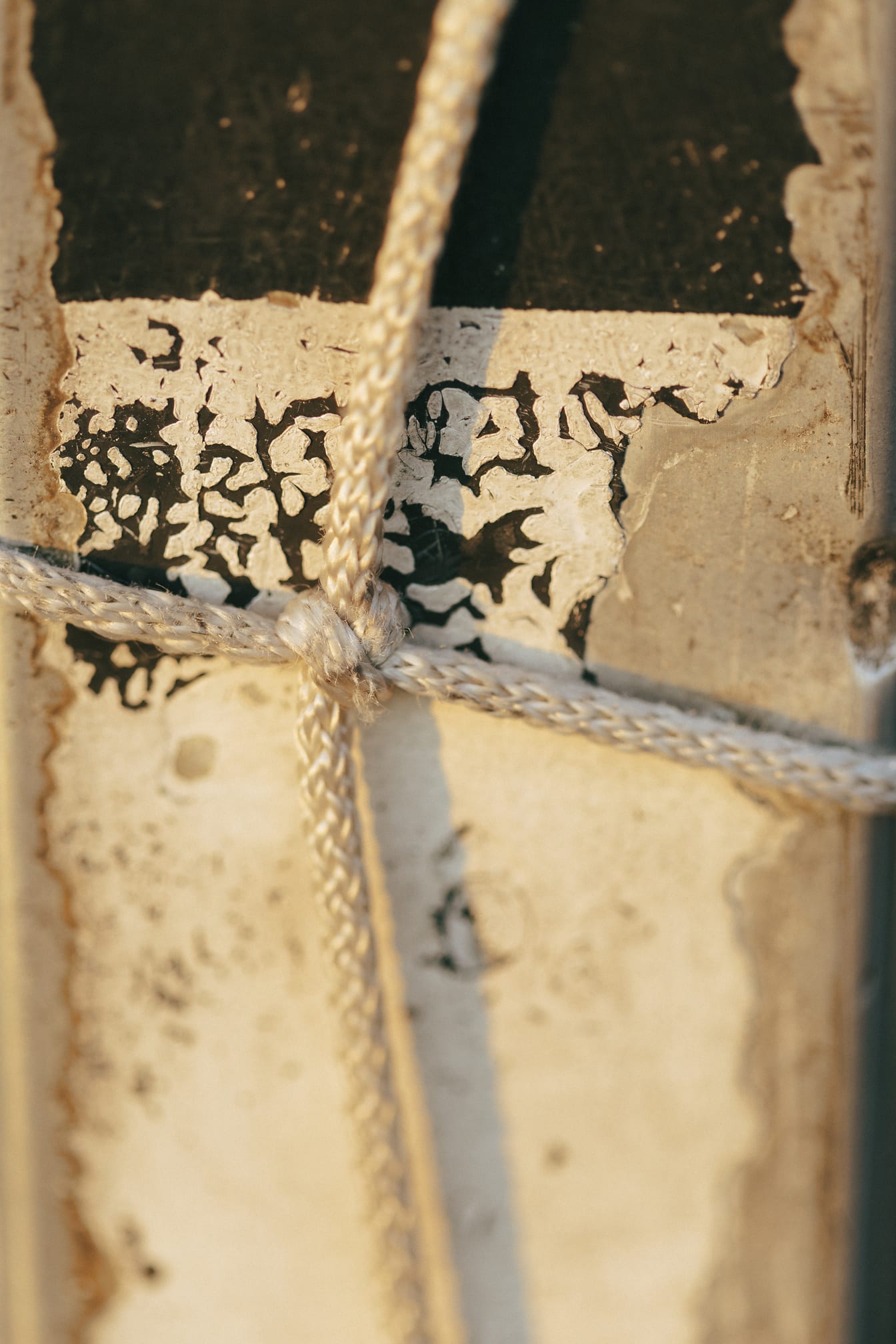 Weißes Nylonseil mit Knoten mit Grunge-Wand als Hintergrund
