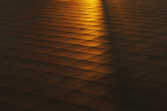 La luce del sole giallo arancione che brilla su un pavimento piastrellato