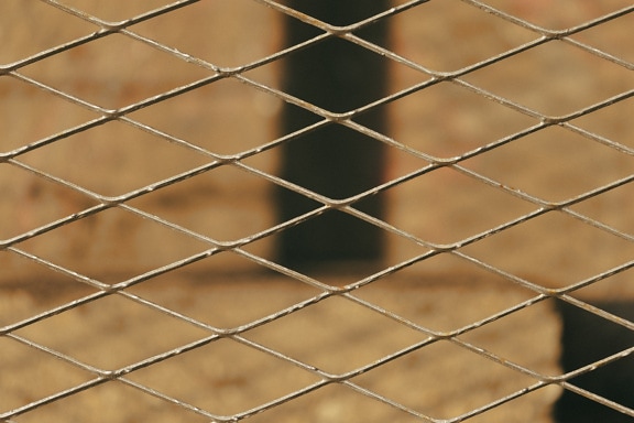 Tekstur pagar besi cor dengan pola geometris belah ketupat horizontal