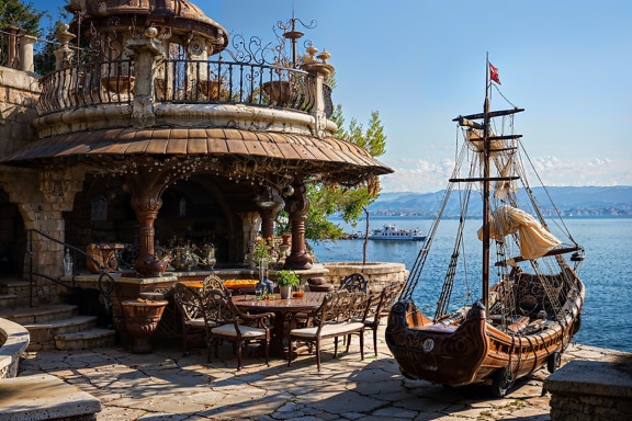 Exterior rústico do restaurante à beira-mar com decoração de navio pirata na Croácia
