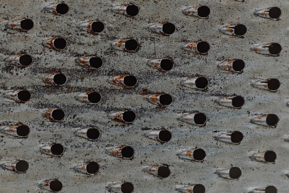 De textuur van de metaalrasp met gaten en roestig oppervlak
