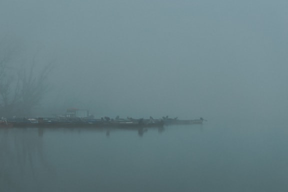 Attracca con le barche sul lago Tikvara nella fitta nebbia