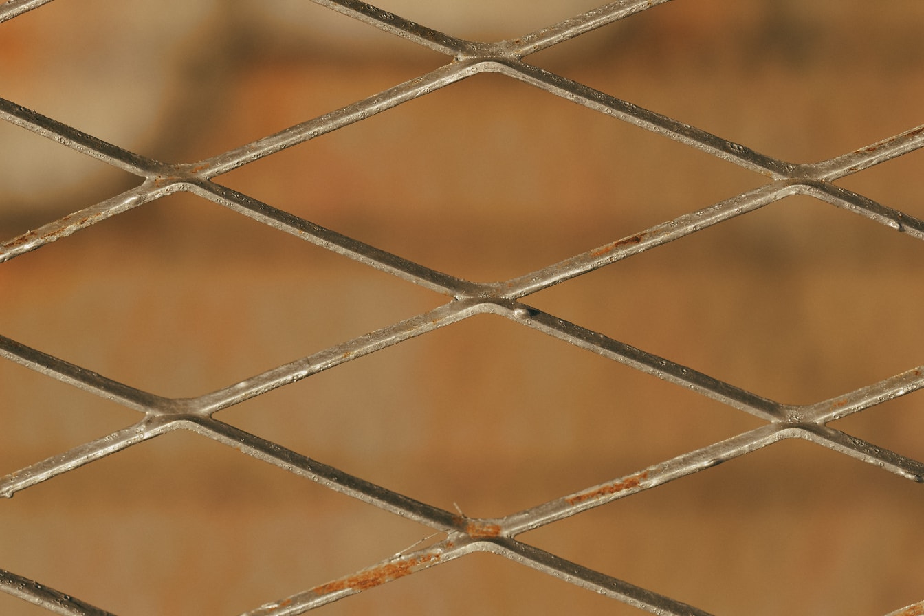 Pagar logam besi cor dengan tekstur close up pola belah ketupat horizontal