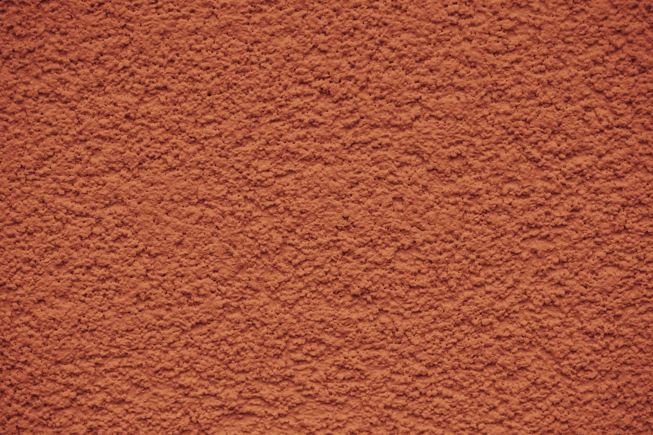 Tekstur dinding dengan semen berwarna oranye dengan tekstur kasar
