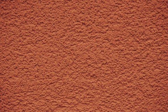 Textura de uma parede com cimento de cor laranja com textura áspera