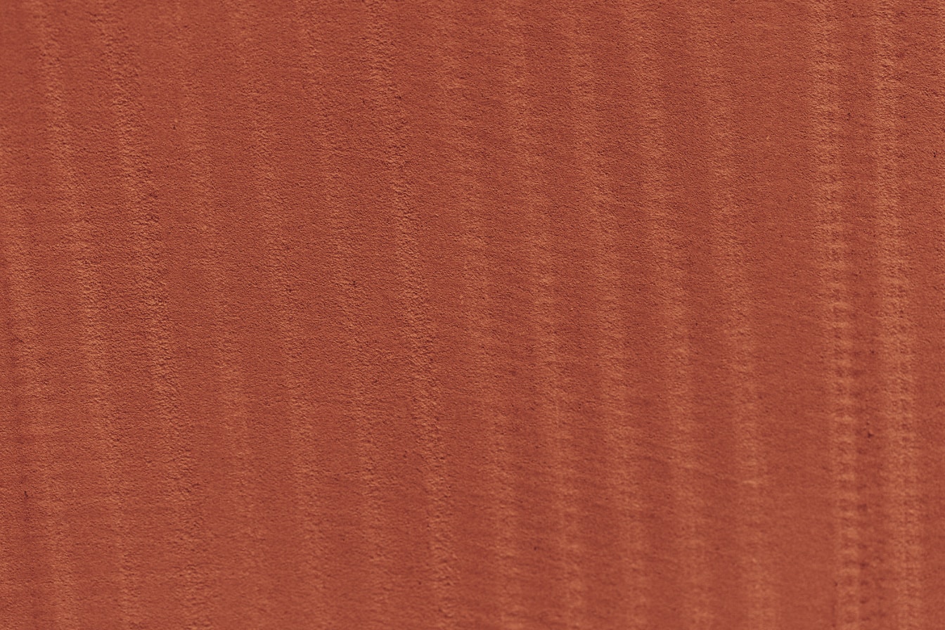 Texture di una superficie di cemento rosso con linee verticali