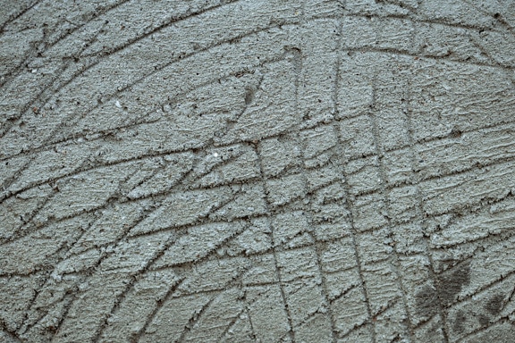 Tekstur beton kasar dengan semen di permukaan dan dengan garis-garis di atasnya
